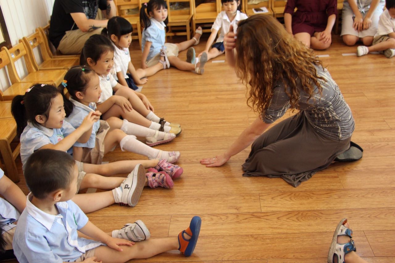 Teacher speaking to children on floor