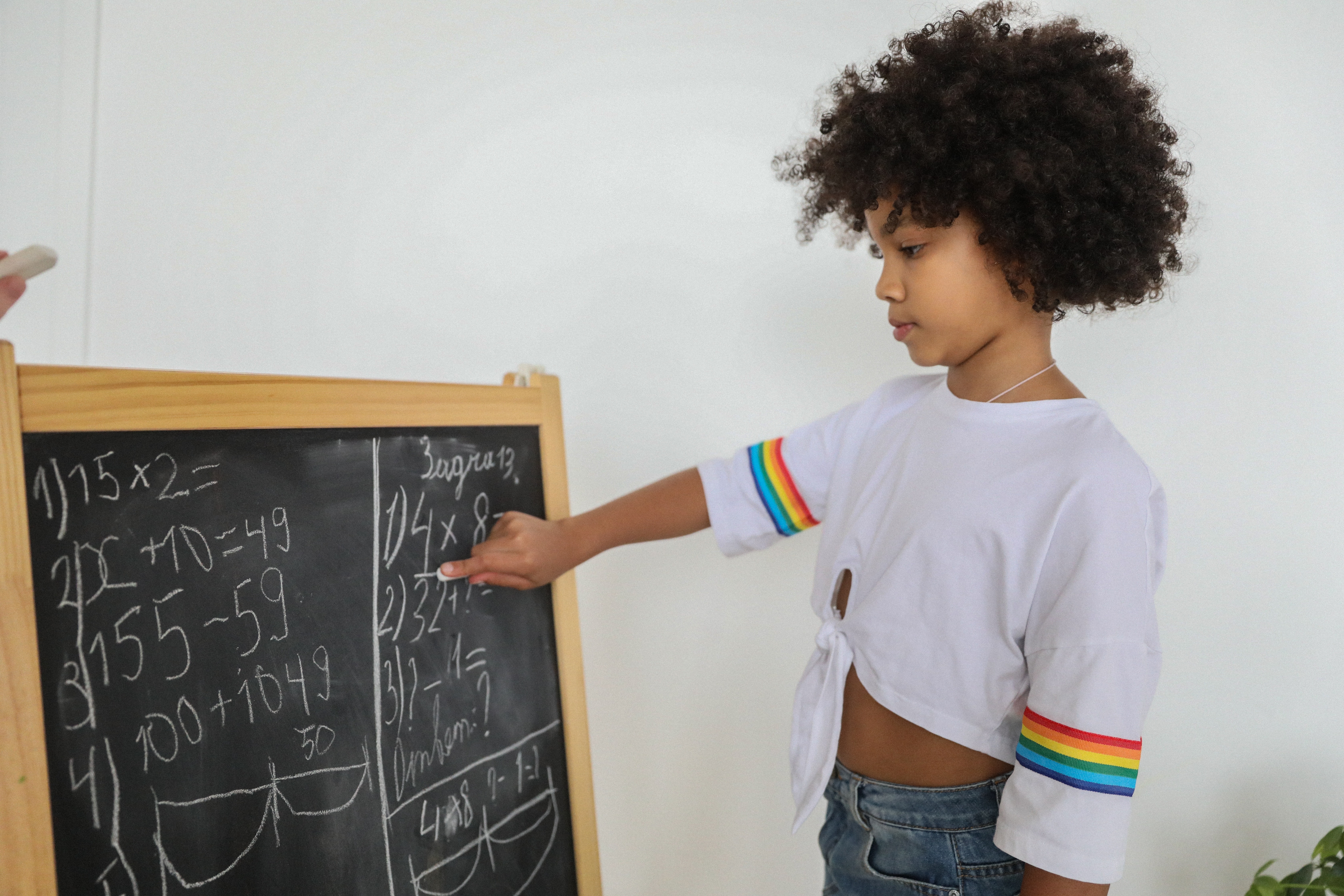 Child pointing to math blackboard