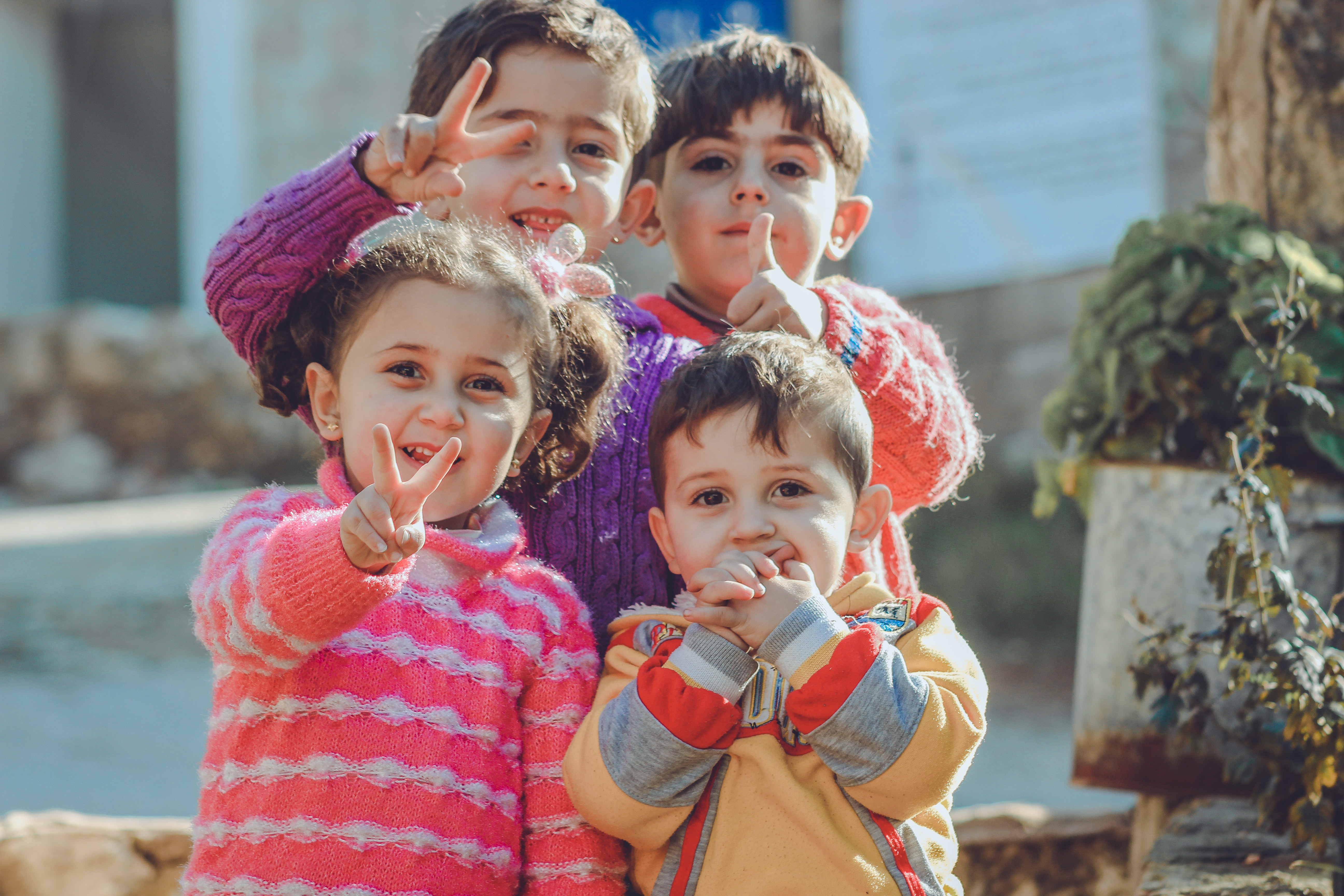 Children from another country facing the camera and smiling with peace signs